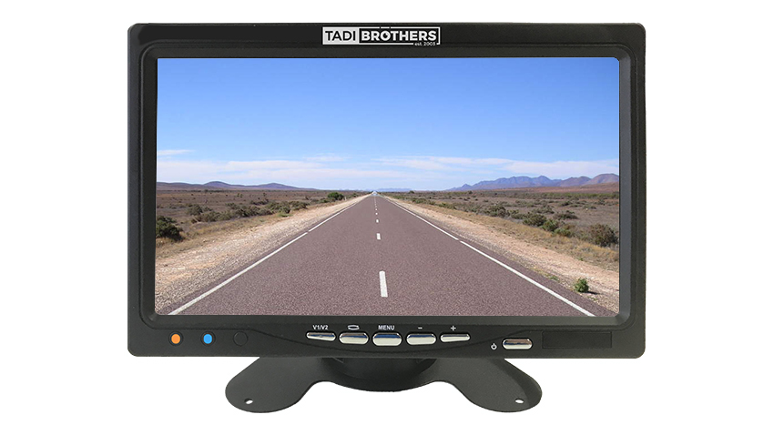 :7-inch LCD rear view monitor by Tadi Brothers displaying a road view on a dashboard stand.